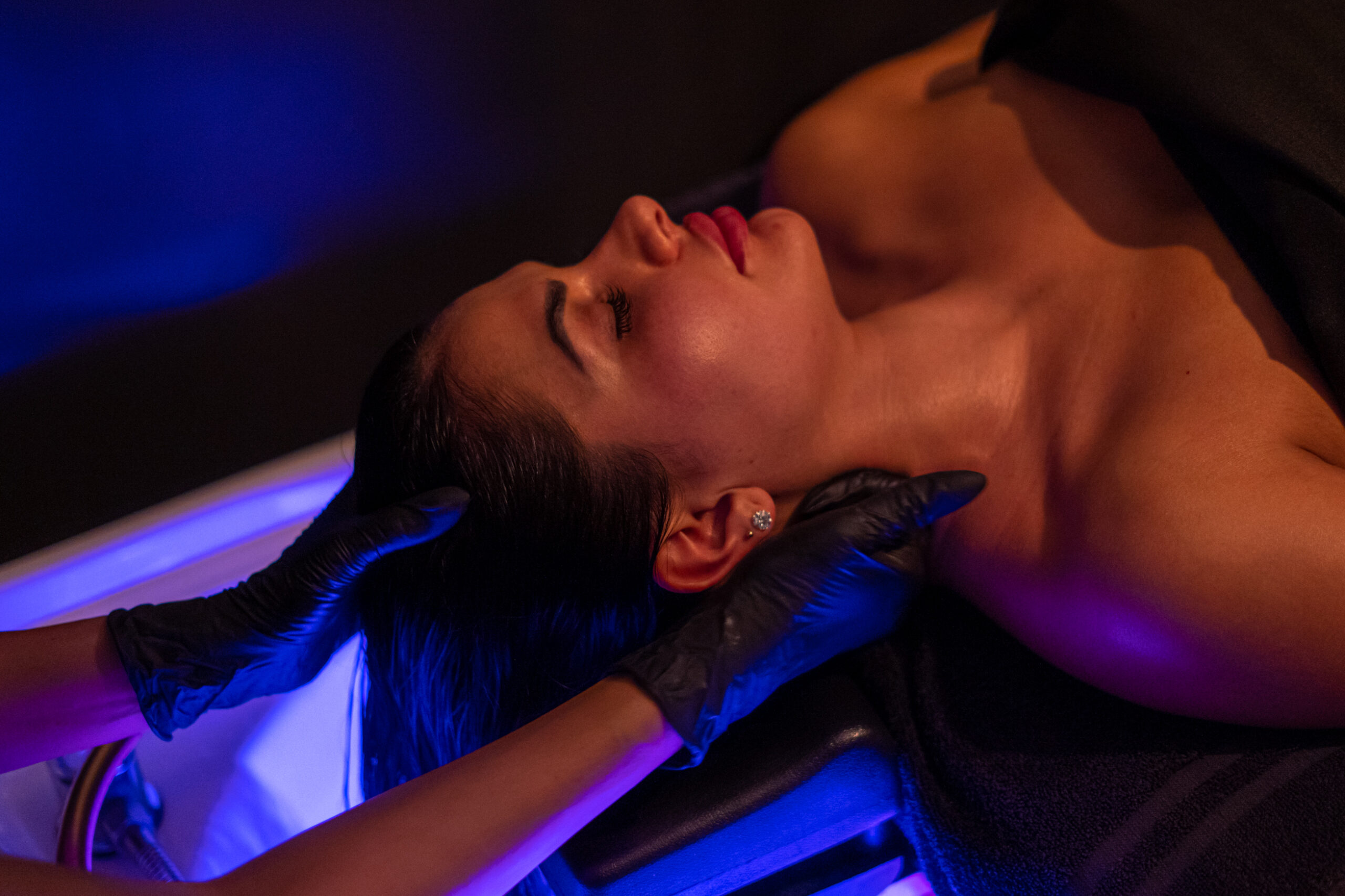 Deeply relaxed woman undergoing a scalp treatment